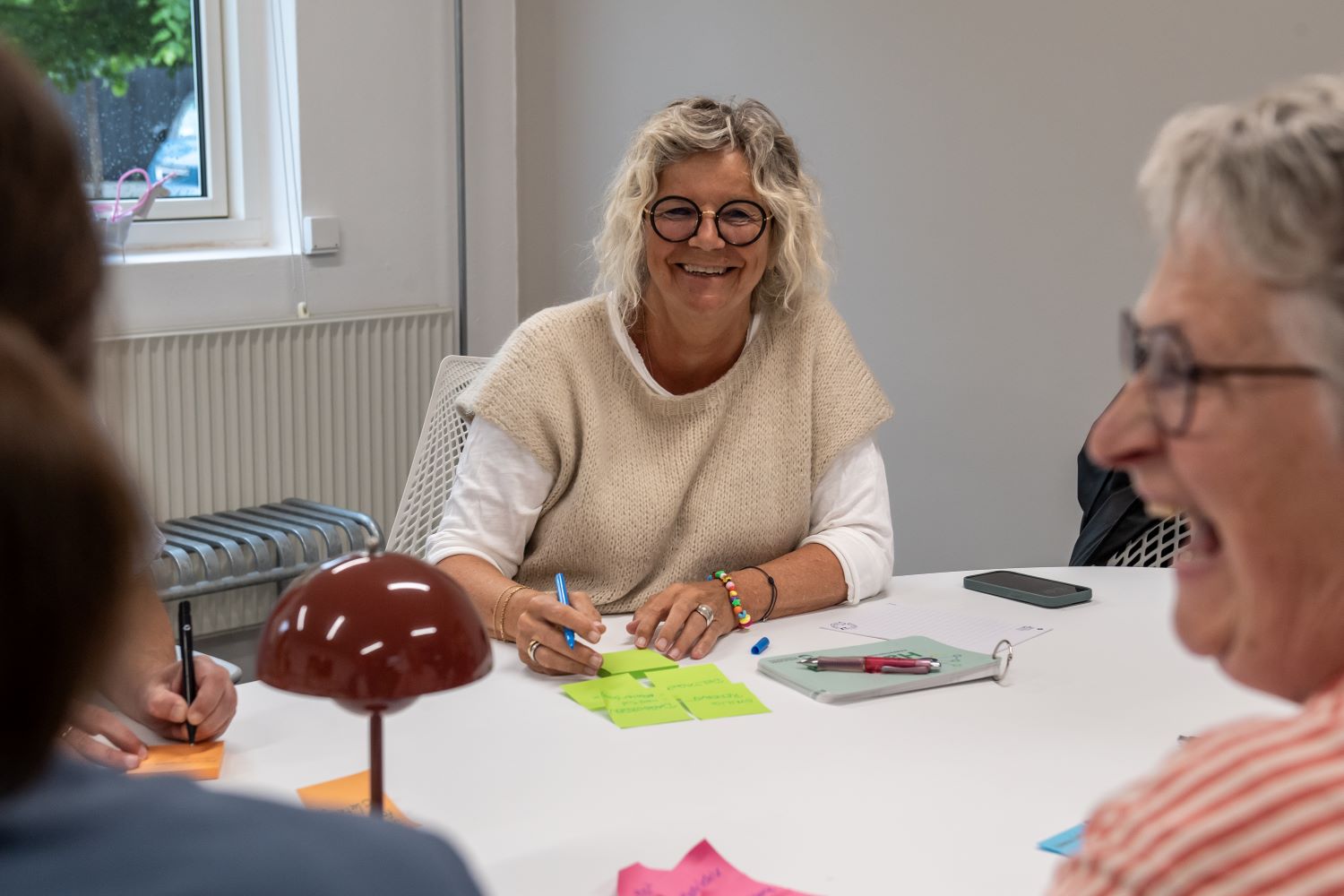 2 smilende kvinder sidder ved et bord